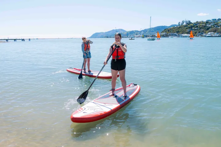 two ladies having learnt to stand up on our paddleboarding lesson in Nelson New Zealand