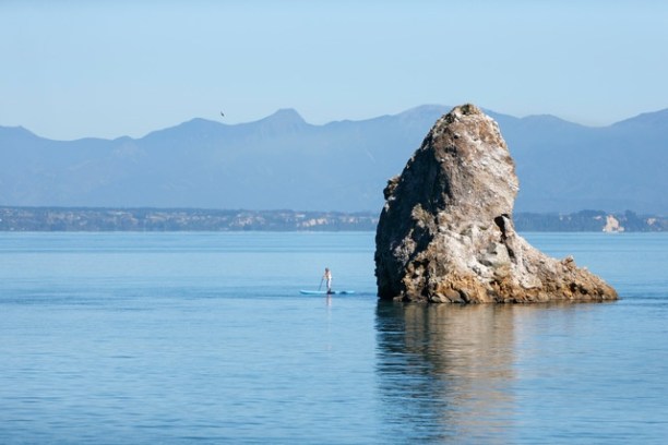 a large body of water with a mountain in the background